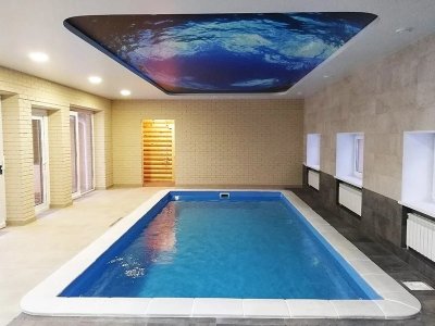 Прямоугольный бассейн в комнате с плиточными стенами и потолком с изображением под водой